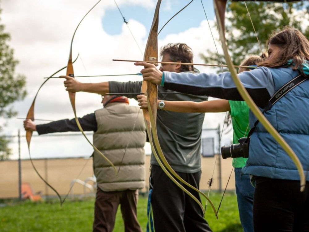 three person practicing using arrow