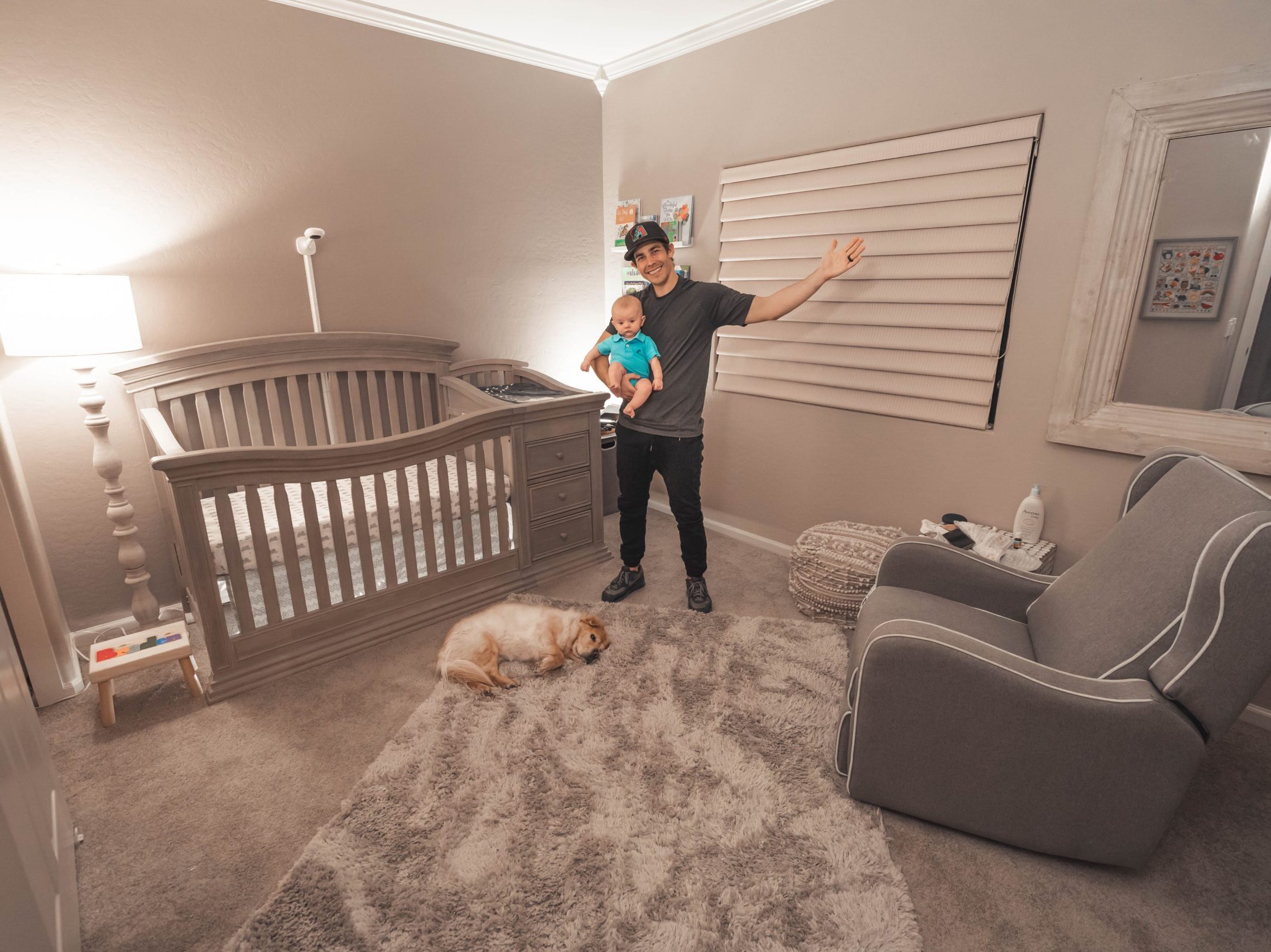 man in black t-shirt and black pants standing beside brown dog
