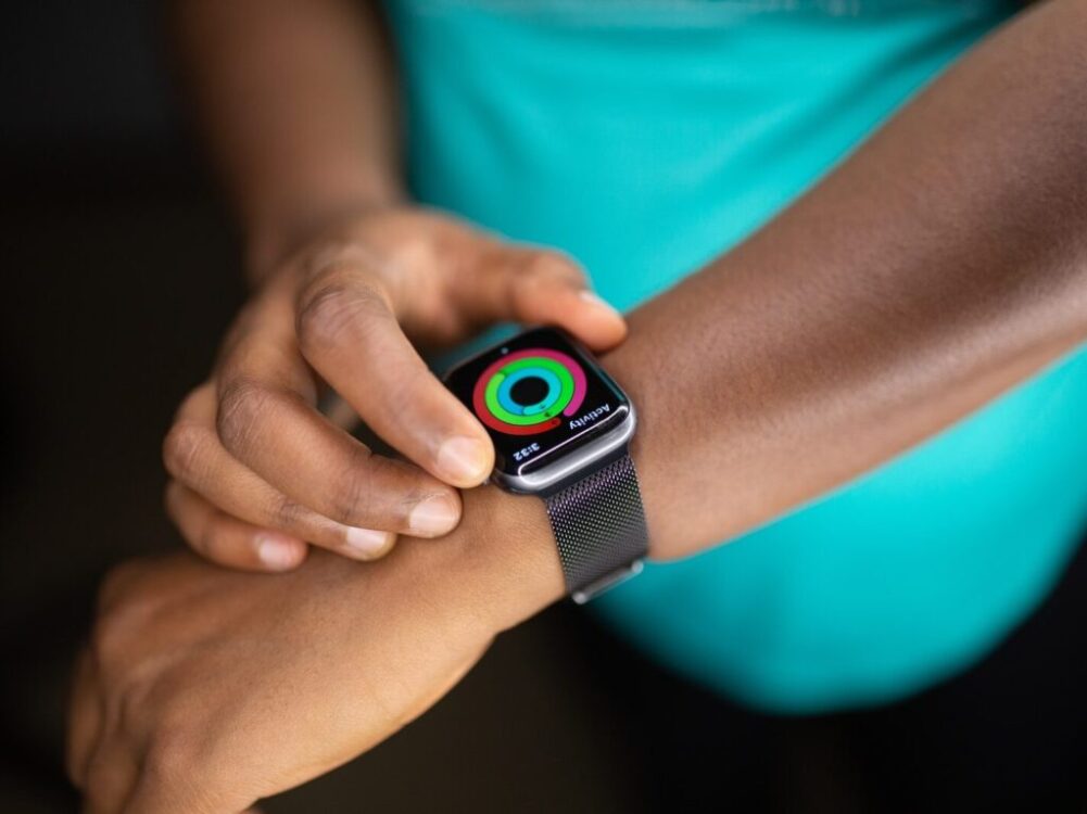 person wearing silver aluminum case apple watch with white sport band