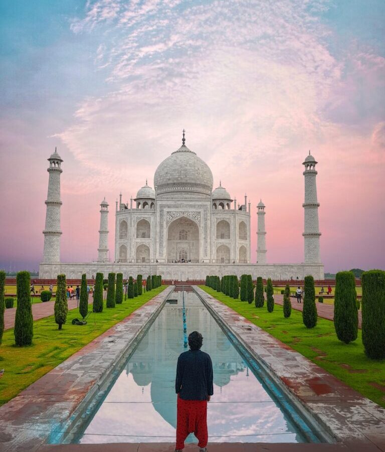 man in black jacket standing in front of white concrete building during daytime