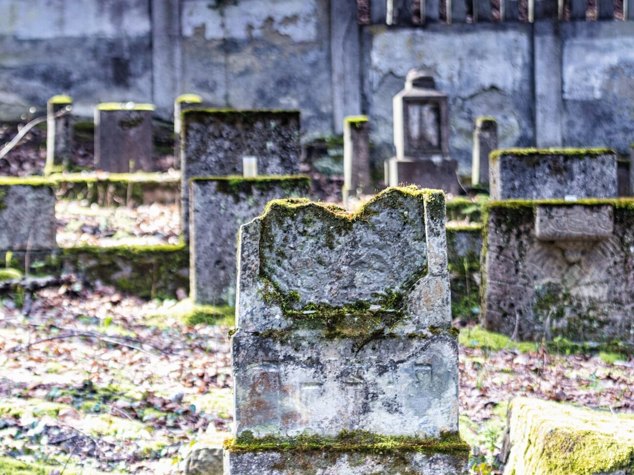 an old cemetery with moss growing on the headstones
