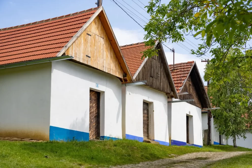 Chaloupky s bílými zdmi a modrými podrovnávkami